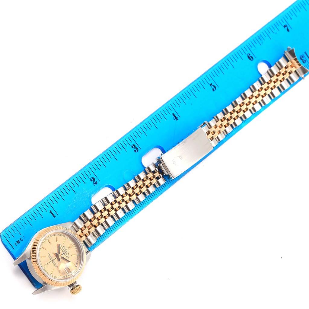 The image shows a Rolex Datejust 69173 Women's Stainless Steel Champagne Dial 69173 Women's Stainless Steel Champagne Dial watch laid against a blue ruler, displaying its face and two-tone metal bracelet.