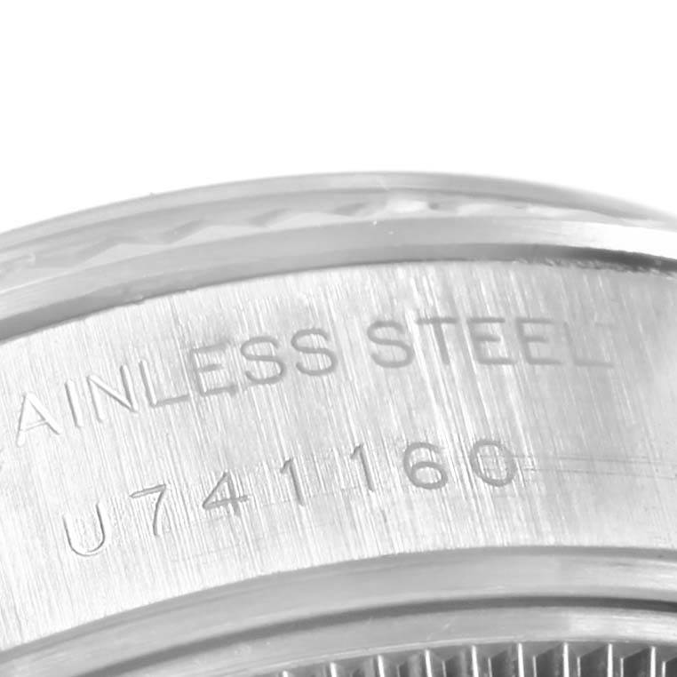 The image shows a close-up of the side of a Rolex Datejust 69174 Women's Stainless Steel Silver Dial 69174 Women's Stainless Steel Silver Dial watch case, highlighting the "STAINLESS STEEL" engraving and serial number.