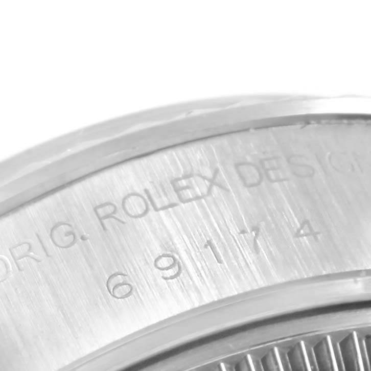 The image shows a close-up of the side engraving on a Rolex Datejust 69174 Women's Stainless Steel Silver Dial 69174 Women's Stainless Steel Silver Dial watch case.