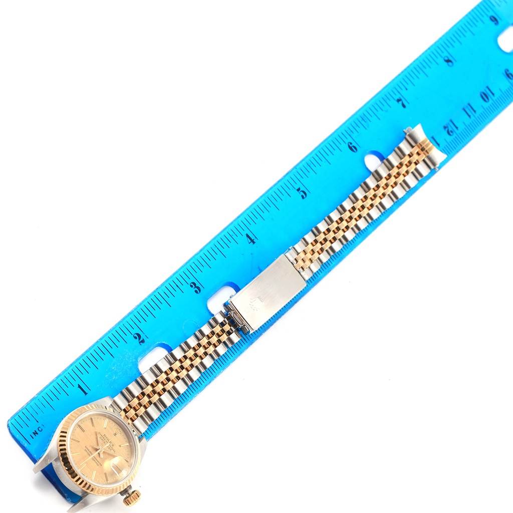 The image shows the Rolex 69173 Men's Stainless Steel Champagne Dial 69173 Men's Stainless Steel Champagne Dial Datejust Steel Yellow Gold Champagne Linen Dial Ladies Watch 69173 laid flat next to a ruler.