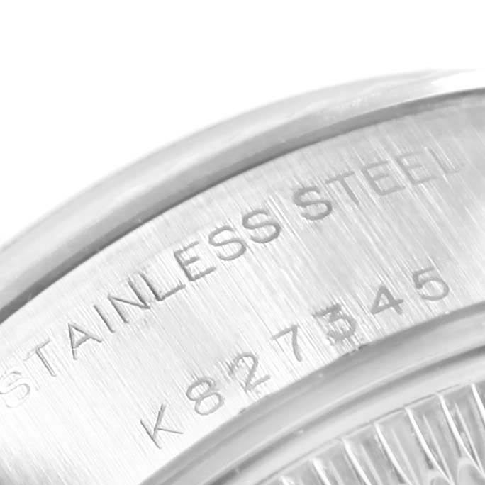 The image shows a close-up of the side of a Rolex Datejust 79174 Women's Stainless Steel Silver Dial 79174 Women's Stainless Steel Silver Dial watch case, highlighting the "STAINLESS STEEL" engraving and serial number.