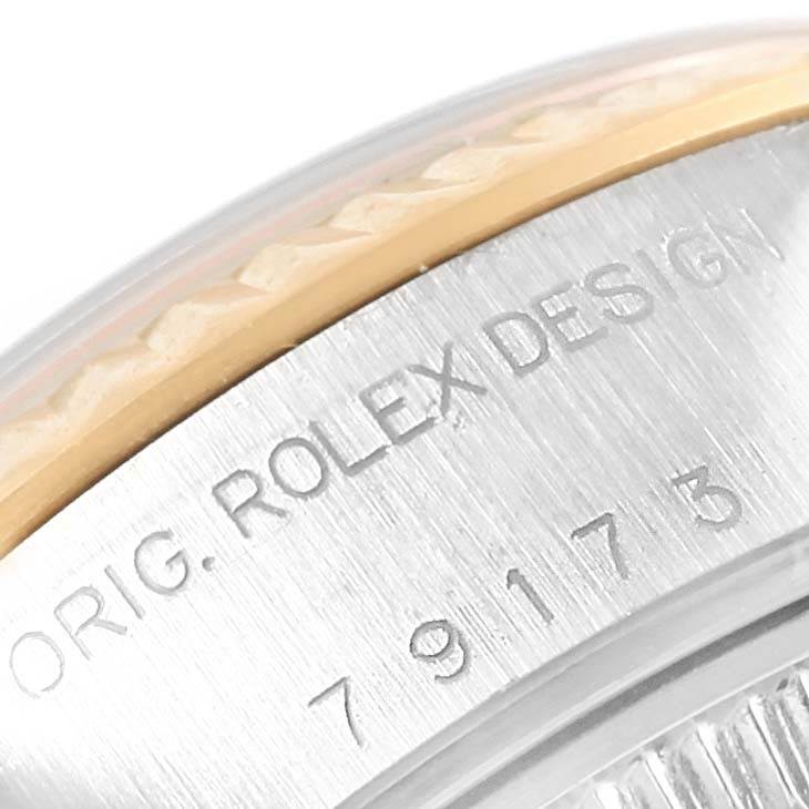 The image shows a close-up of the engraved case side and bezel of the Rolex Datejust 79173 Women's Steel and Gold (two tone) White Dial 79173 Women's Steel and Gold (two tone) White Dial watch.