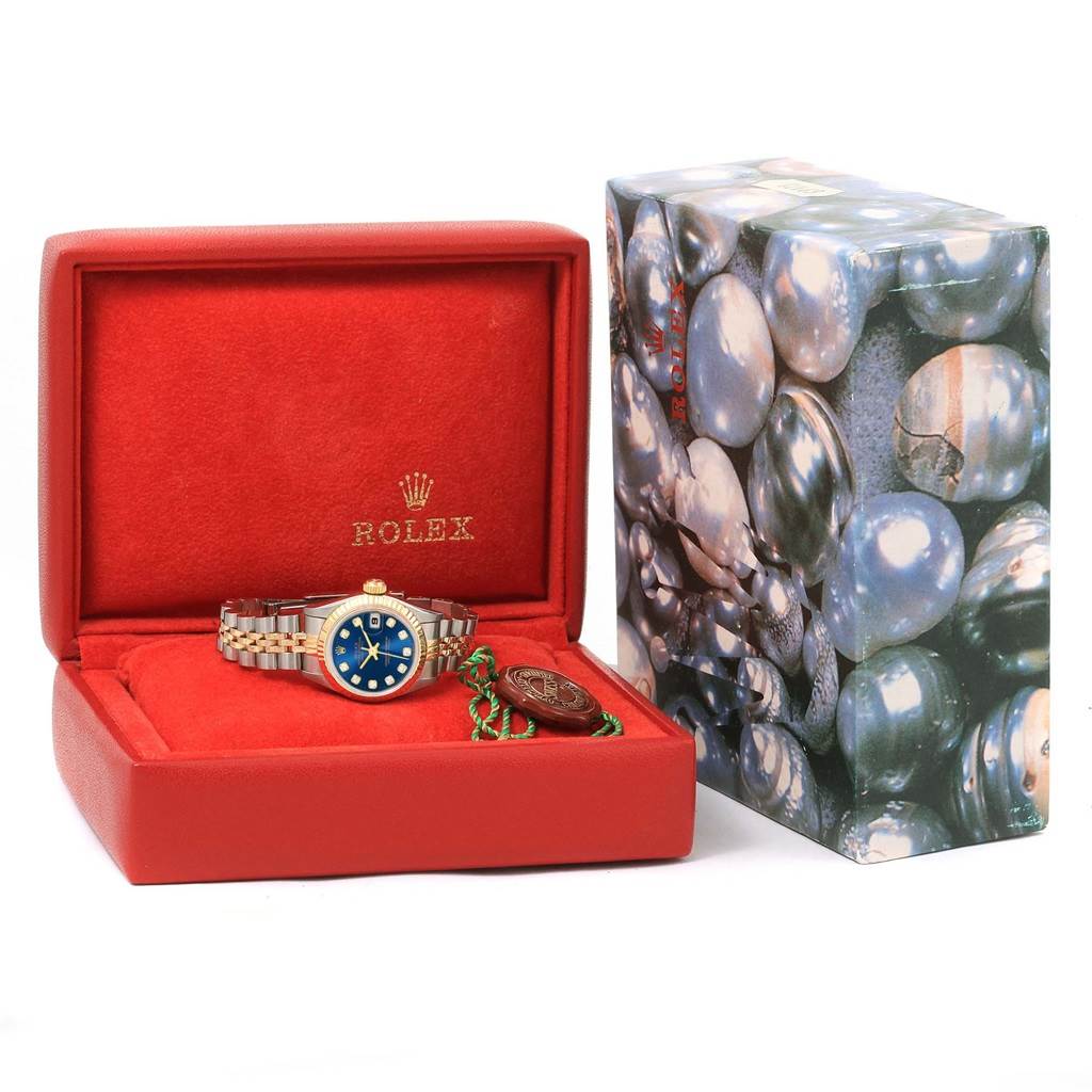 The Rolex Datejust 69173 Women's Steel and Gold (two tone) Blue Dial 69173 Women's Steel and Gold (two tone) Blue Dial watch is displayed in its open box, showing the watch face, bracelet, and accompanying tags.