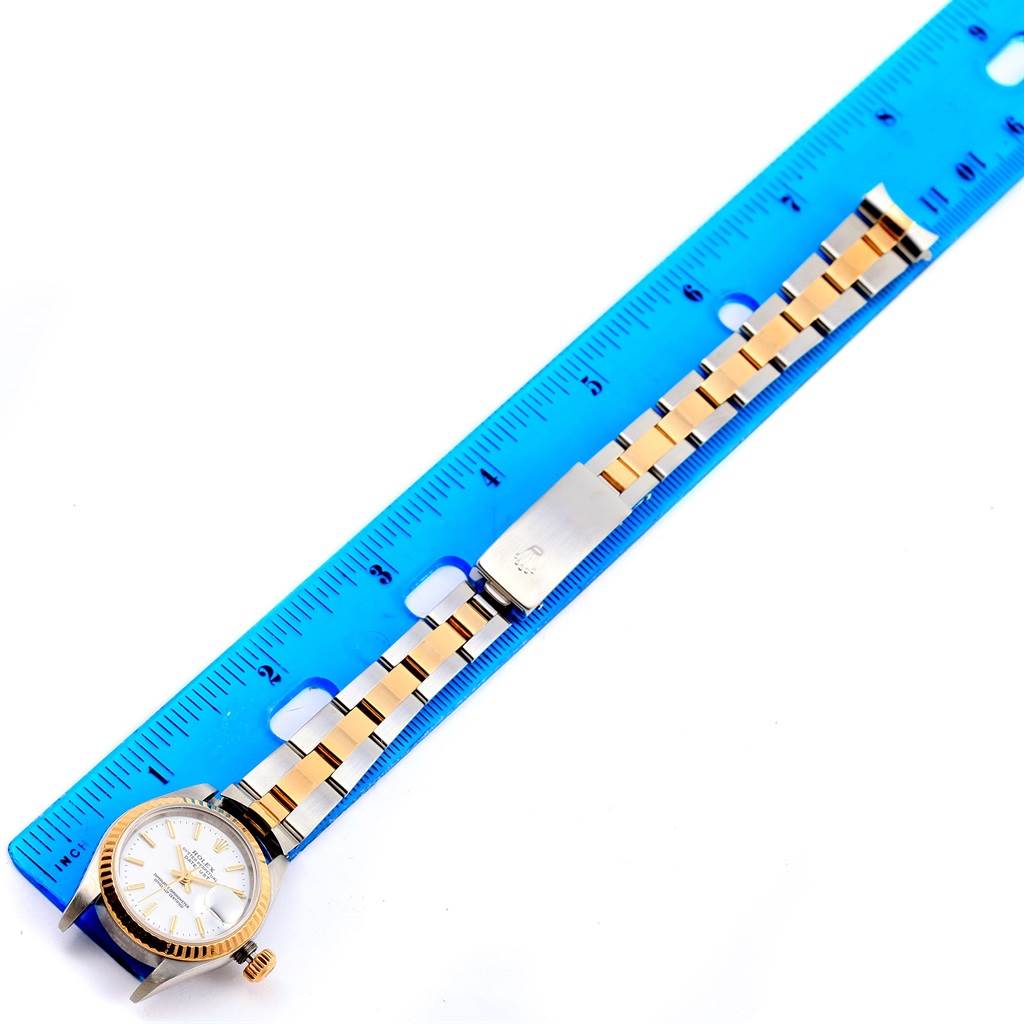 The Rolex Datejust 79173 Women's Steel and Gold (two tone) White Dial 79173 Women's Steel and Gold (two tone) White Dial watch is shown laying flat with the face, links, and clasp visible, measured against a ruler.