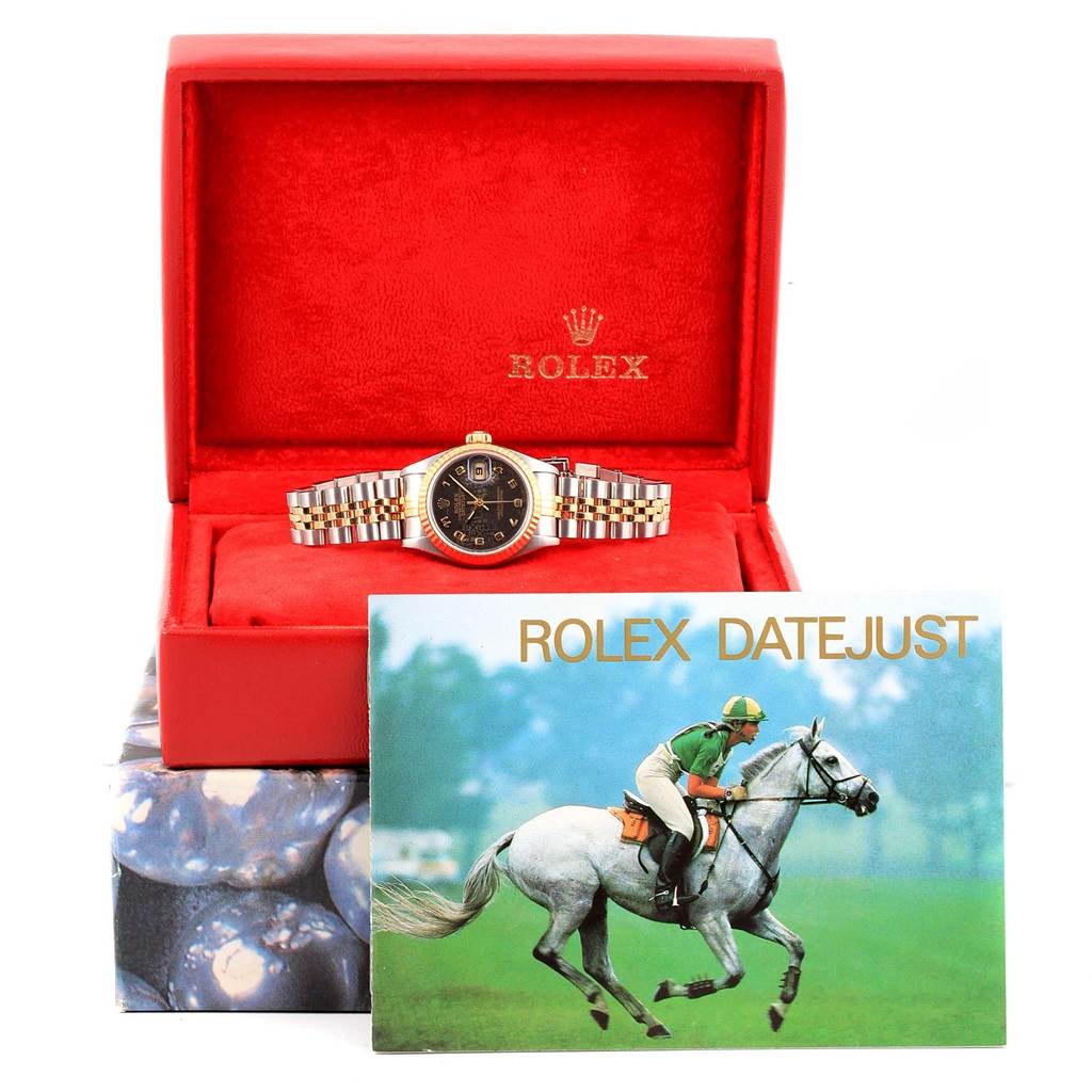 The Rolex Datejust 79173 Women's Stainless Steel Black Dial 79173 Women's Stainless Steel Black Dial watch is displayed front-on in its red box with a brochure in the foreground.