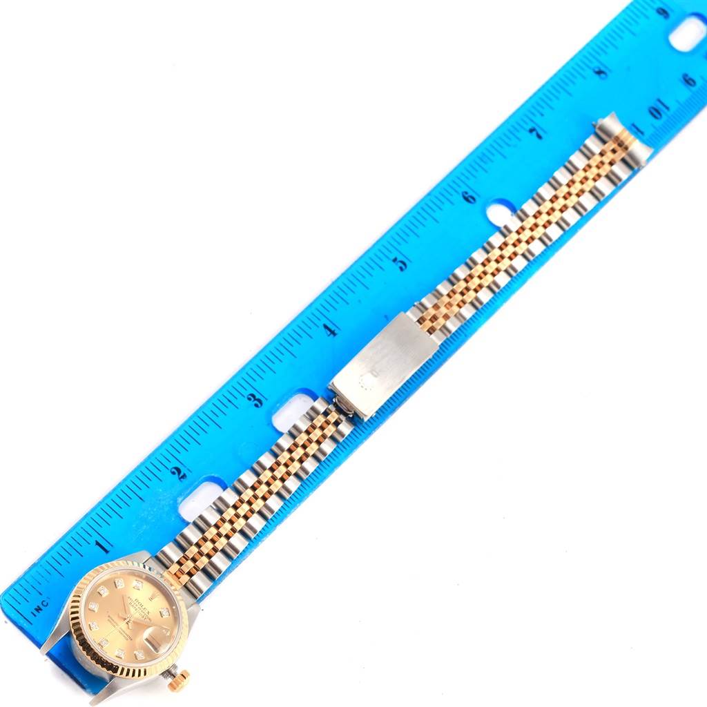 The image shows a Rolex Datejust 79173 Women's Stainless Steel Champagne Dial 79173 Women's Stainless Steel Champagne Dial watch, laying flat, with a jubilee bracelet aligned against a blue ruler for measurement.