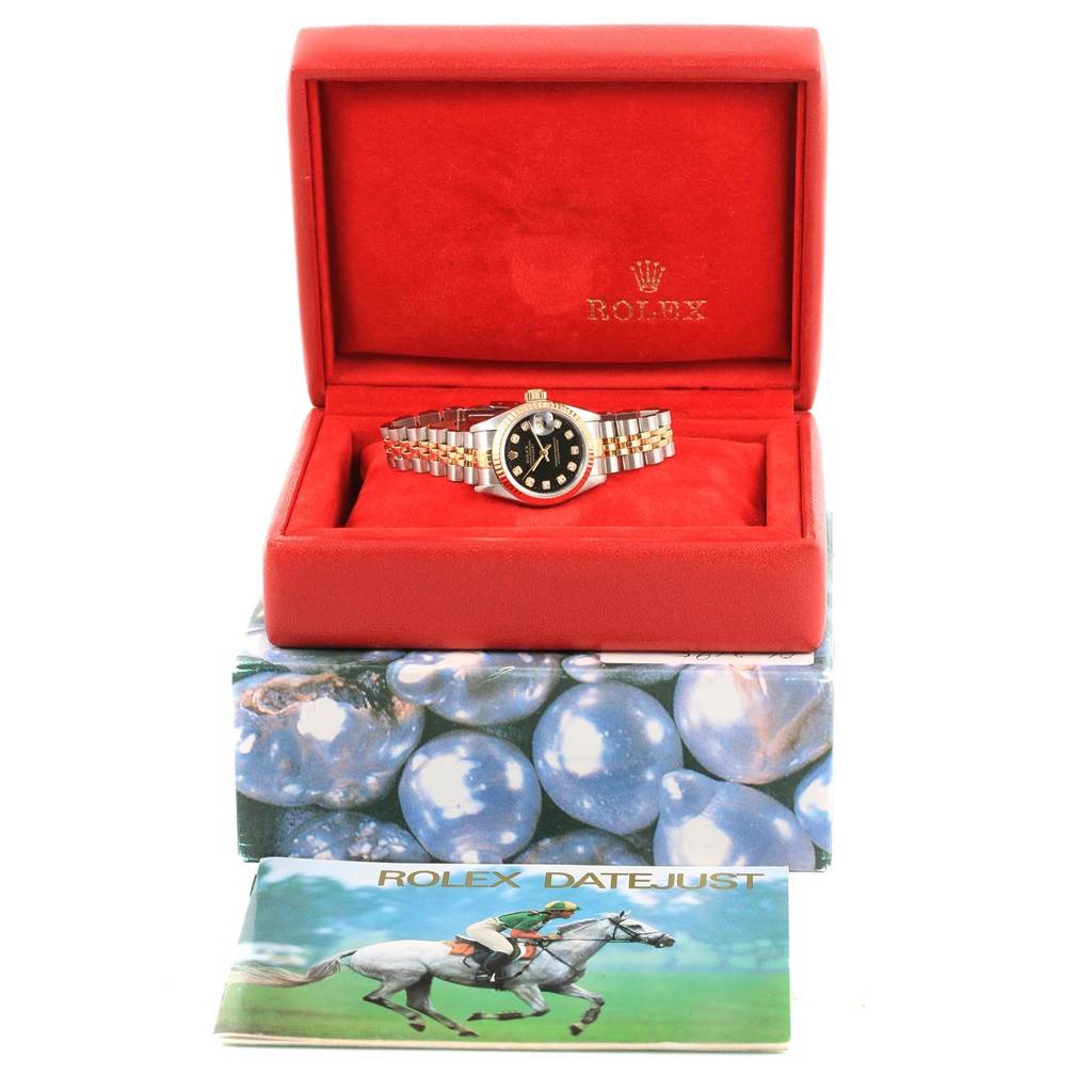 The Rolex Datejust 69173 Women's Stainless Steel Black Dial 69173 Women's Stainless Steel Black Dial watch is displayed in an open red box, along with its original packaging and booklet.