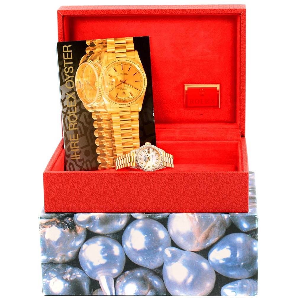 This image shows a Rolex Datejust 69238 Women's Yellow Gold Silver Dial 69238 Women's Yellow Gold Silver Dial model watch, displayed inside an open red box, along with its booklet.