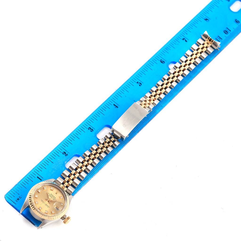 The image shows a Rolex Datejust 6917 Women's Stainless Steel Champagne Dial 6917 Women's Stainless Steel Champagne Dial watch laying flat next to a blue ruler, displaying the face and bracelet.