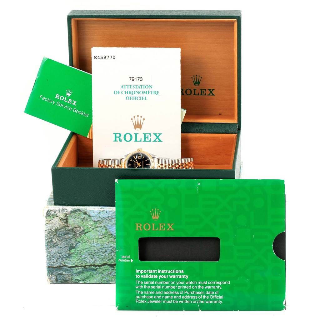 The image shows a Rolex Datejust 79173 Women's Steel and Gold (two tone) Black Dial 79173 Women's Steel and Gold (two tone) Black Dial watch partially visible in its open box, with accompanying booklets and warranty card.