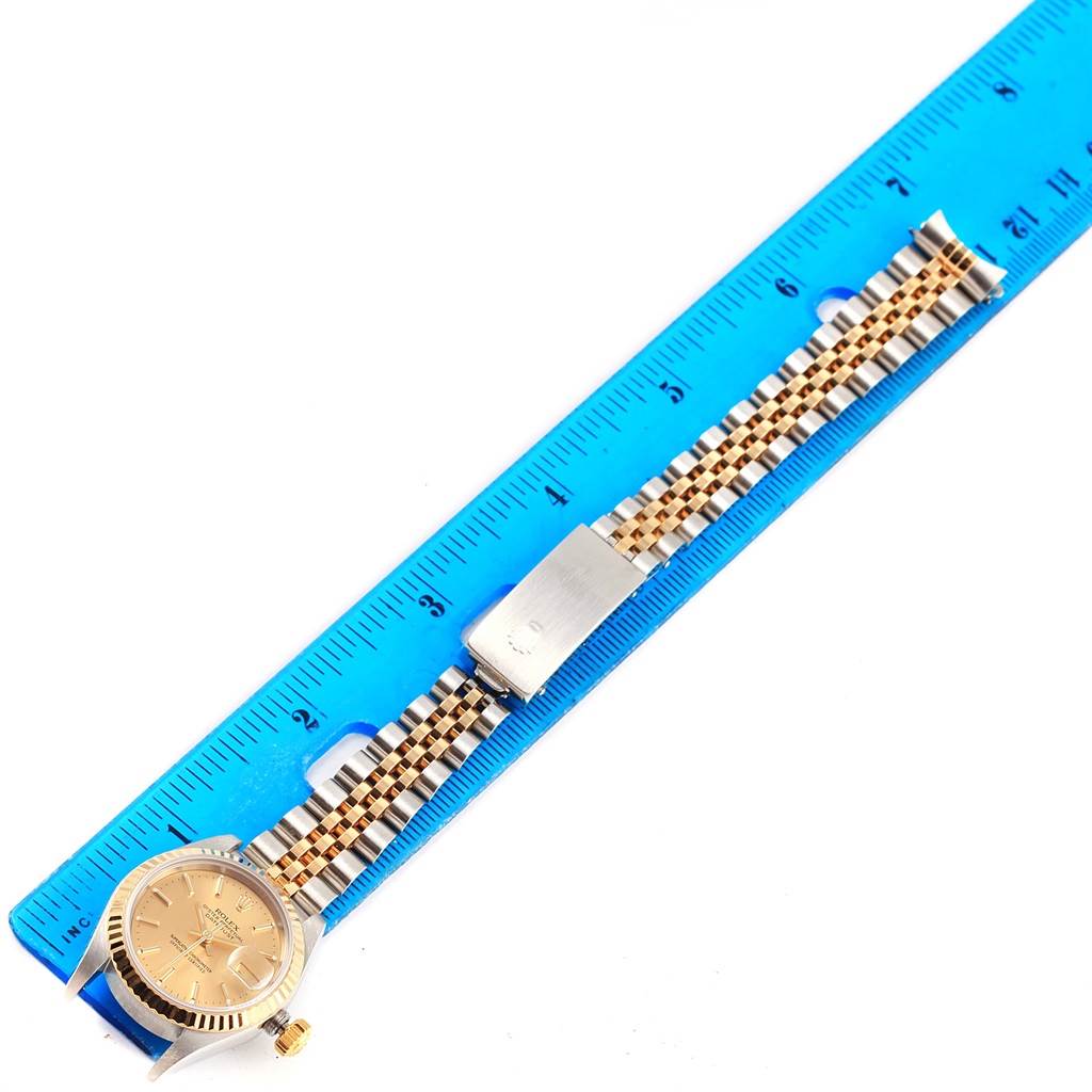 The image shows a Rolex Datejust 79173 Women's Steel and Gold (two tone) Champagne Dial 79173 Women's Steel and Gold (two tone) Champagne Dial watch viewed from above, with its bracelet measured against a blue ruler.