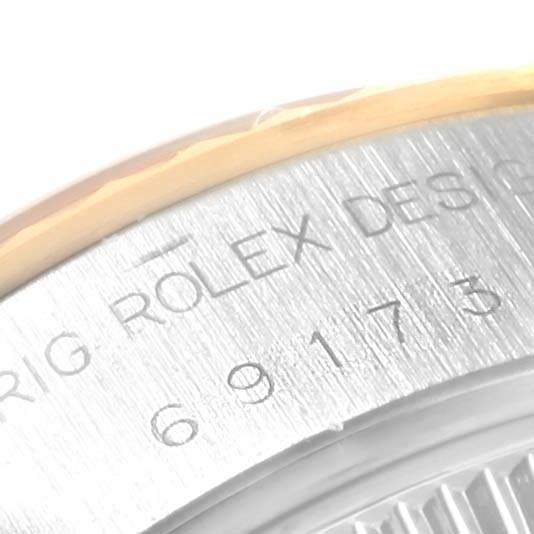 This image shows a close-up of the case side engraving on a Rolex Datejust 69173 Women's Stainless Steel Beige Dial 69173 Women's Stainless Steel Beige Dial watch, including the serial number.