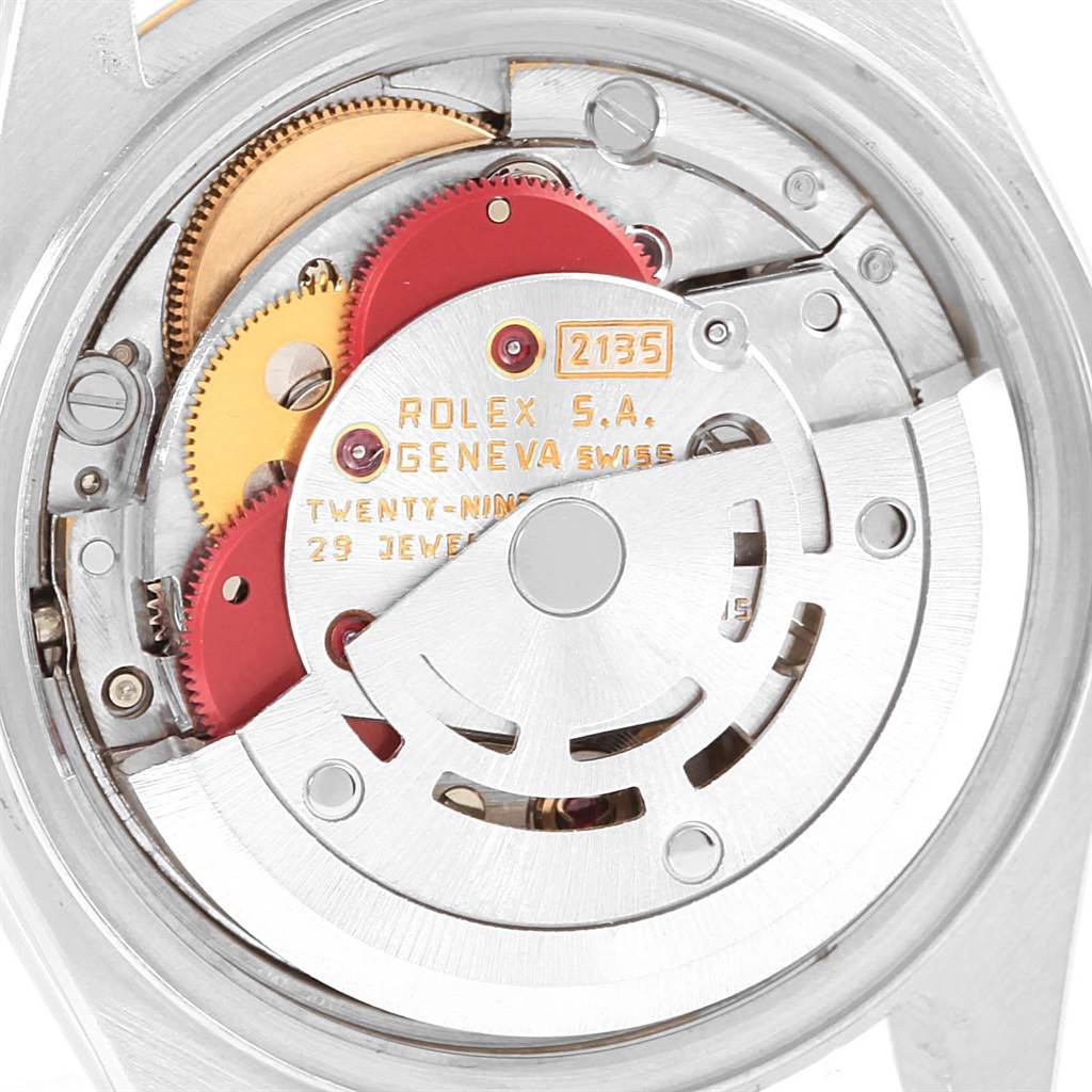 The image shows the internal mechanism of a Rolex Datejust 69173 Women's Stainless Steel White Dial 69173 Women's Stainless Steel White Dial watch, viewed from the back, highlighting gears and inscriptions.
