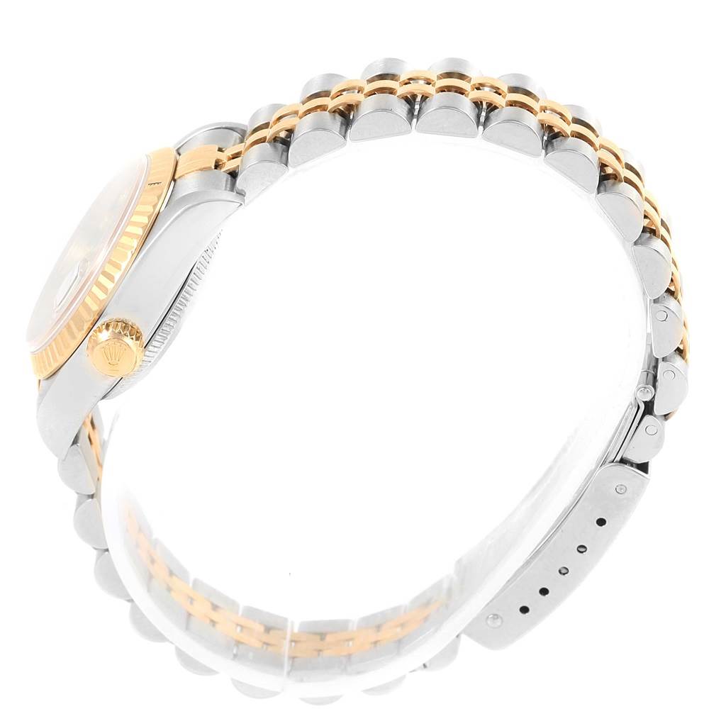 The image shows a side view of a Rolex Datejust 79173 Women's Stainless Steel Silver Dial 79173 Women's Stainless Steel Silver Dial watch, highlighting the gold crown, part of the case, and Jubilee bracelet.