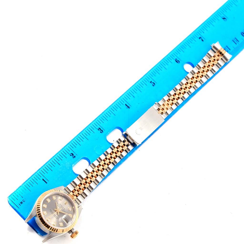 The image shows a Rolex Datejust 79173 Women's Stainless Steel Silver Dial 79173 Women's Stainless Steel Silver Dial watch laid flat next to a ruler, showcasing the face and full length of the band.