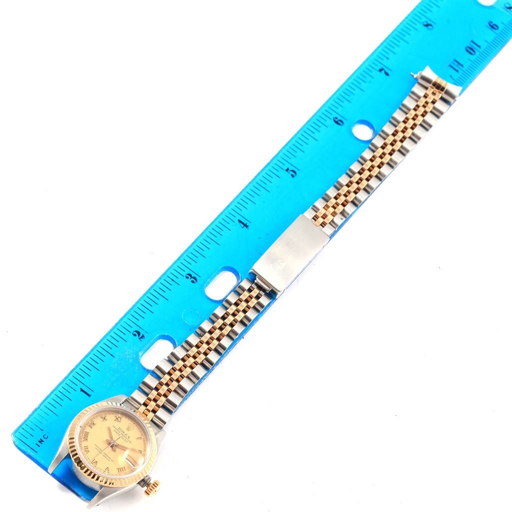 This image shows a Rolex Datejust 69163 Women's Stainless Steel Champagne Dial 69163 Women's Stainless Steel Champagne Dial watch with a two-tone jubilee bracelet, positioned alongside a blue ruler for scale.