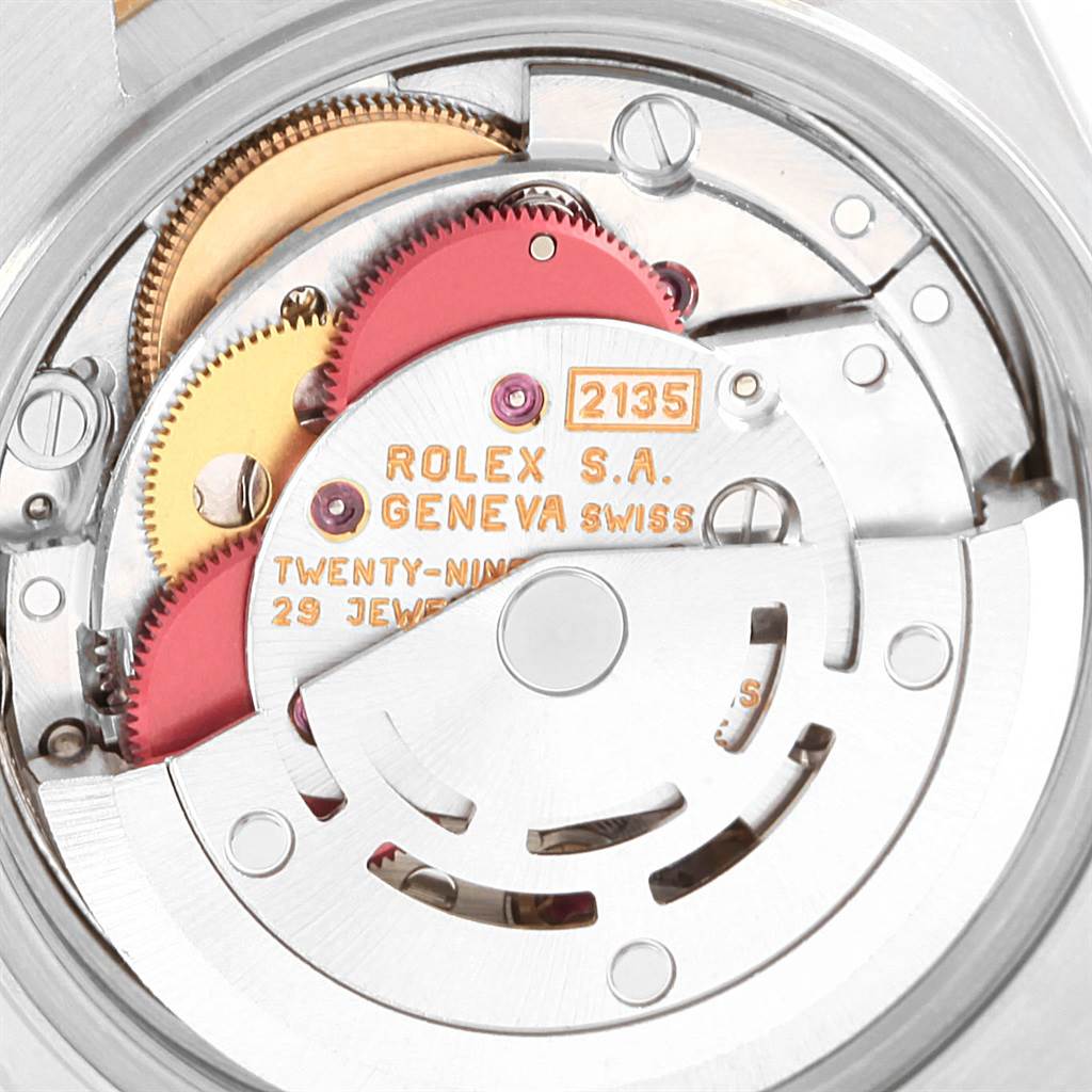 This is a close-up view of the movement of a Rolex Datejust 69173 Women's Stainless Steel White Dial 69173 Women's Stainless Steel White Dial watch from the back, showing gears and the rotor with inscriptions.
