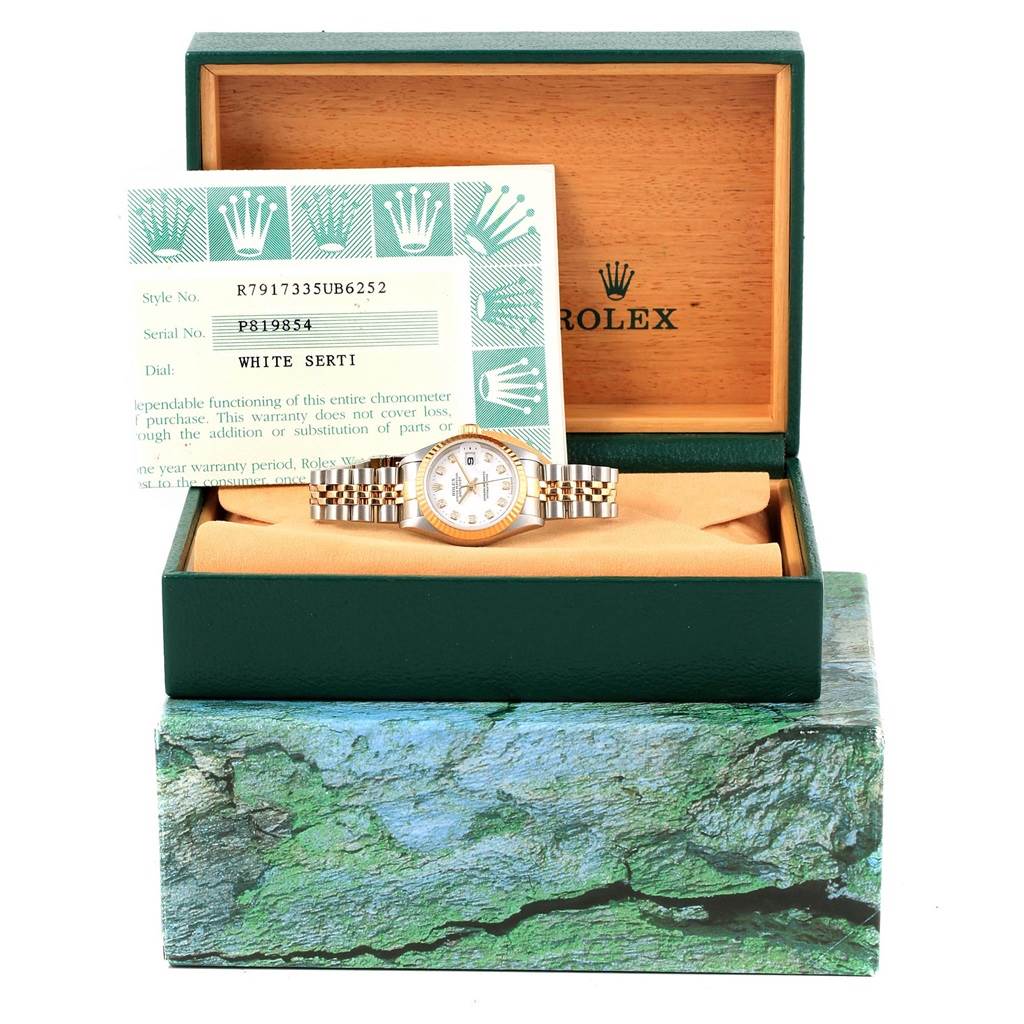 The image shows a front view of a Rolex Datejust 79173 Women's Stainless Steel White Dial 79173 Women's Stainless Steel White Dial model watch in its box, accompanied by a warranty card.