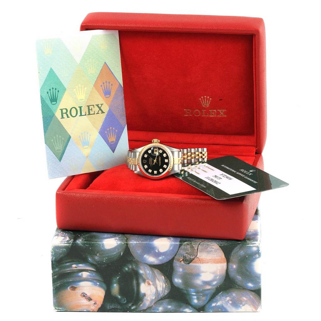 This Rolex Datejust 79173 Women's Stainless Steel Black Dial 79173 Women's Stainless Steel Black Dial watch is displayed in its red box, accompanied by a warranty card and informational booklet.