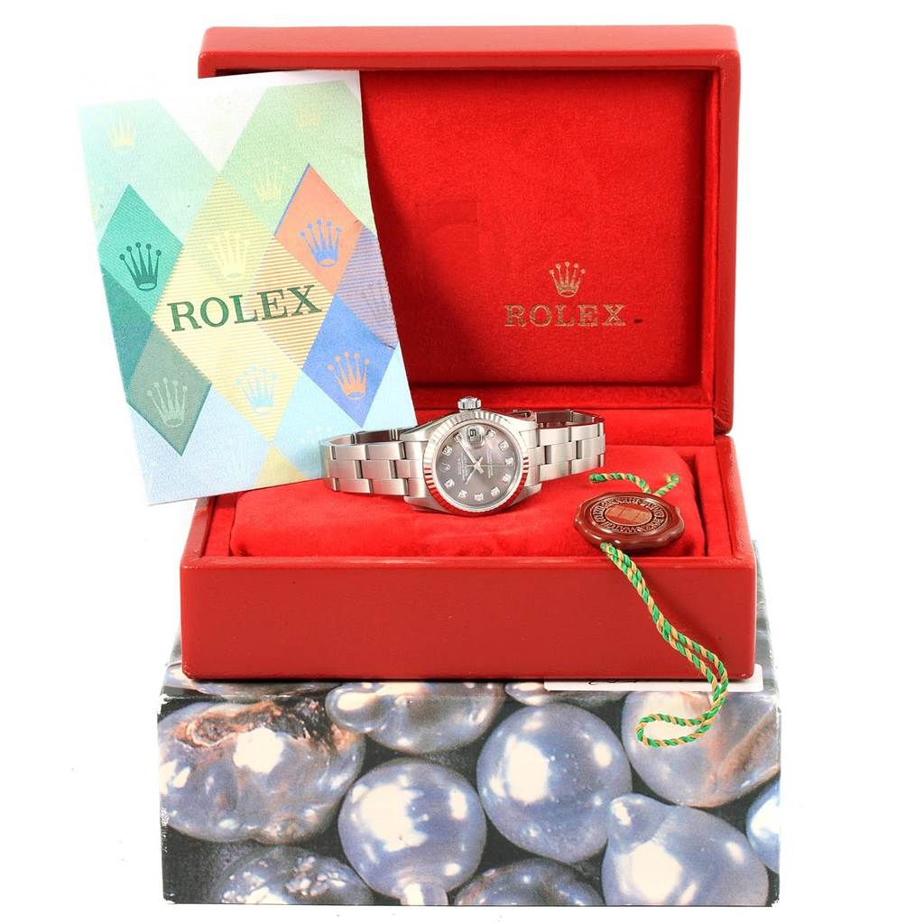 This image shows a Rolex Datejust 79174 Women
s Stainless Steel Mother of Pearl Dial 79174 Women
s Stainless Steel Mother of Pearl Dial watch inside its open red box, along with paperwork and a tag.