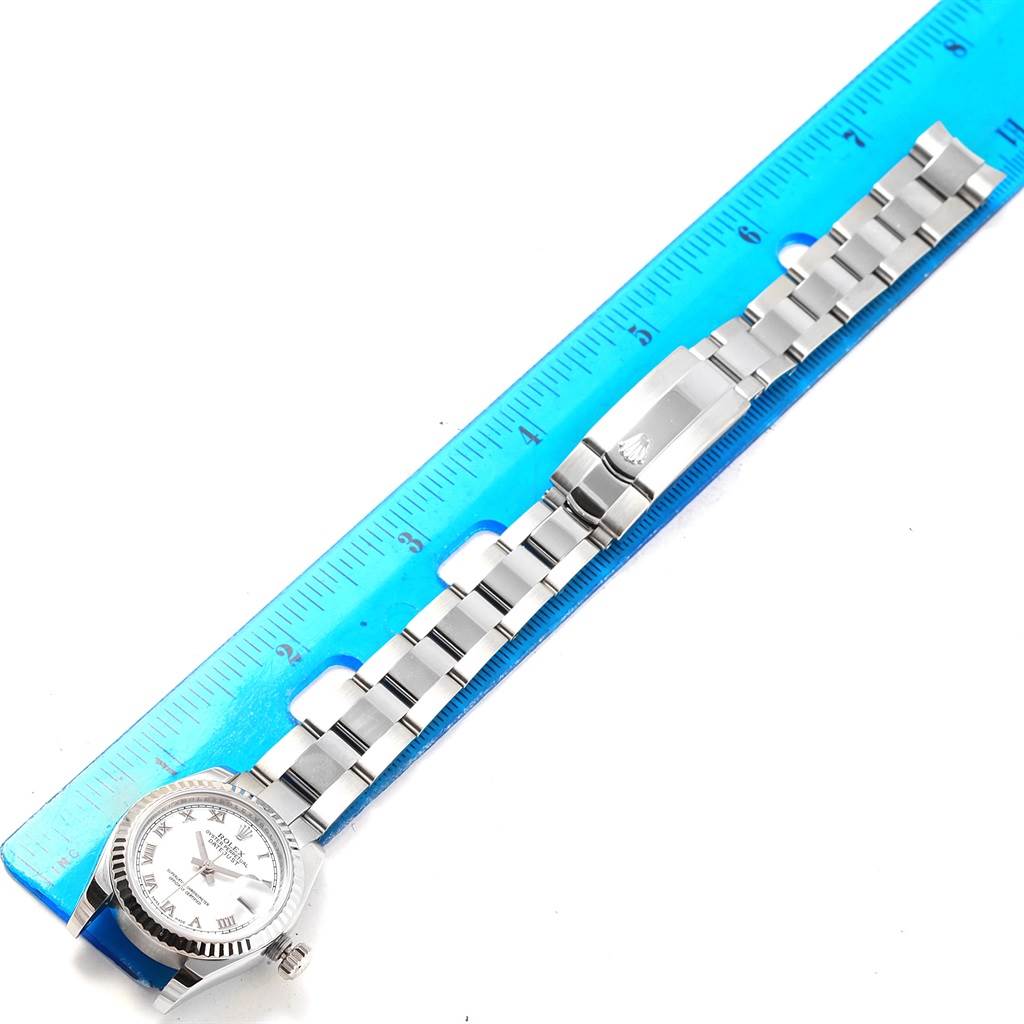 The image shows a Rolex Datejust 179174 Women
s Stainless Steel White Dial 179174 Women
s Stainless Steel White Dial watch laid next to a ruler, displaying the watch face, bracelet, and clasp from a top-down angle.