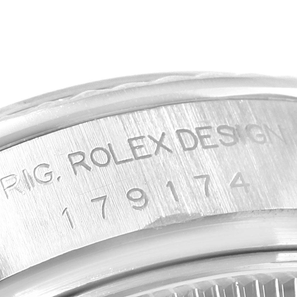 This close-up image shows part of the case with engraved text on a Rolex Datejust 179174 Women
s Stainless Steel White Dial 179174 Women
s Stainless Steel White Dial watch.