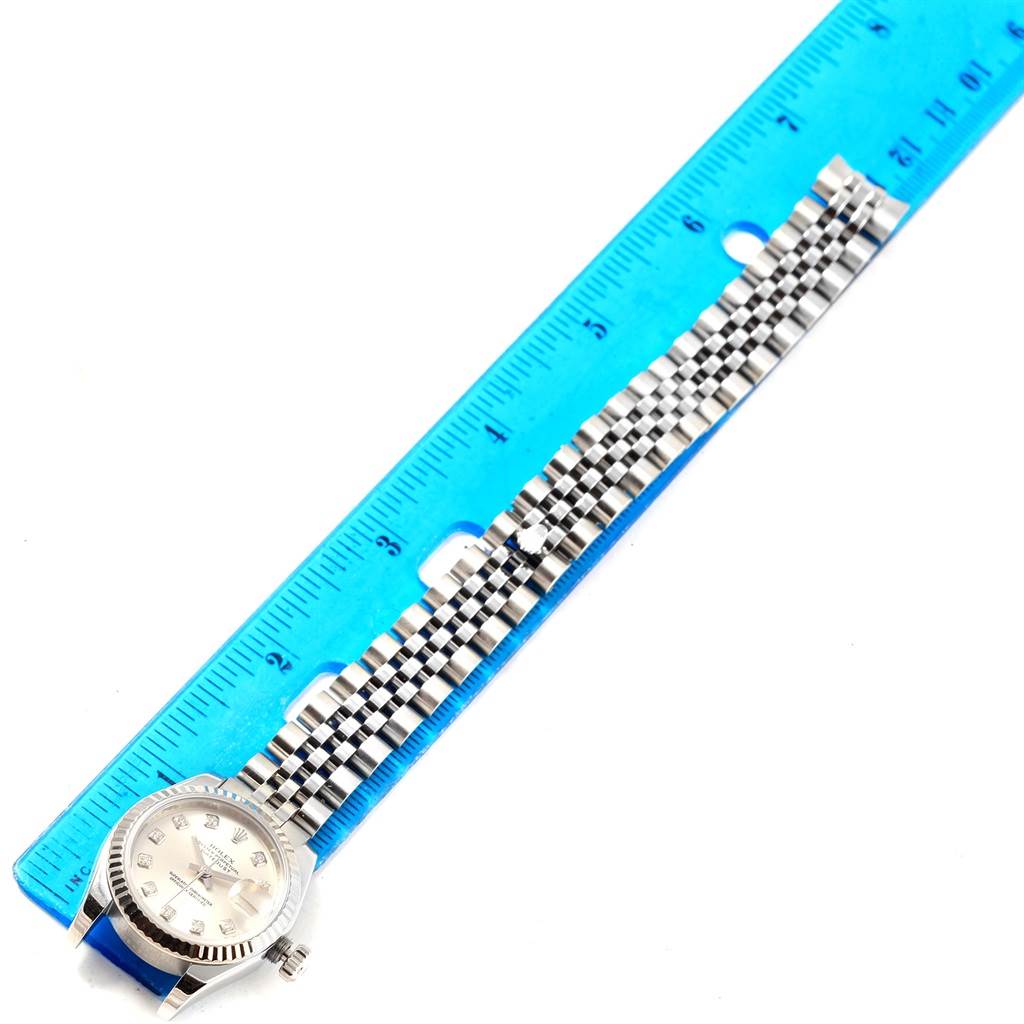 The image shows a Rolex Datejust 179174 Women's Stainless Steel Silver Dial 179174 Women's Stainless Steel Silver Dial model watch laid flat next to a blue ruler, showcasing its face and bracelet from above.