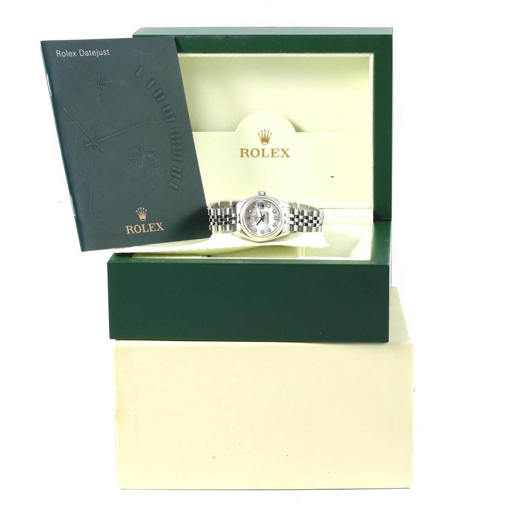 The image shows a Rolex Datejust 179174 Women
s Stainless Steel Mother of Pearl Dial 179174 Women
s Stainless Steel Mother of Pearl Dial watch in its open box, along with a booklet positioned to the left of the box.