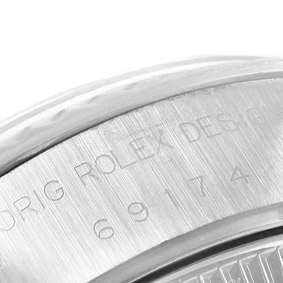 This is a close-up of the outer edge and engraved serial number on the case back of a Rolex Datejust 69174 Women's Stainless Steel Silver Dial 69174 Women's Stainless Steel Silver Dial watch.