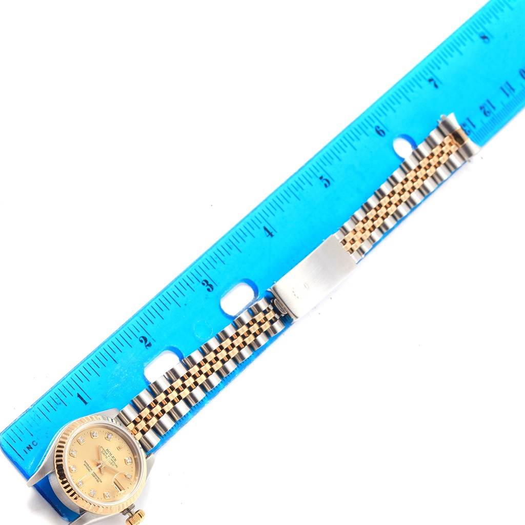 The Rolex Datejust 69173 Women's Stainless Steel Champagne Dial 69173 Women's Stainless Steel Champagne Dial watch is shown from a top-down angle, with the face and bracelet beside a blue ruler for scale.