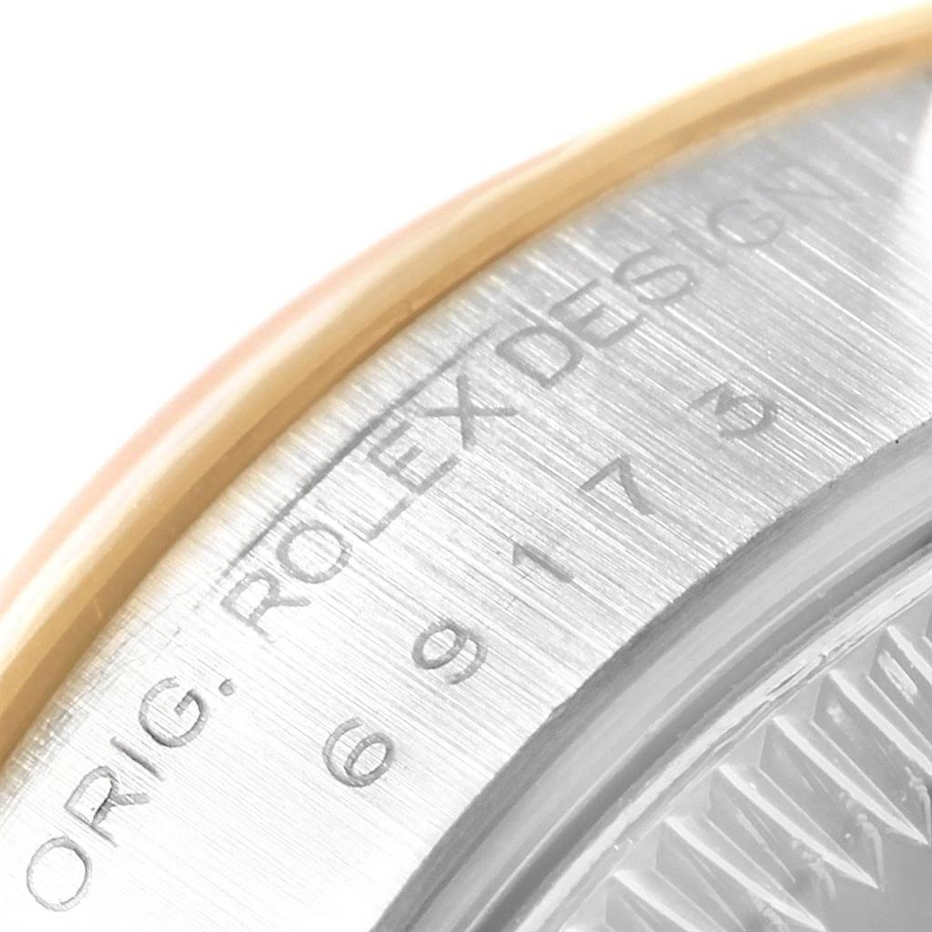 The image shows an up-close view of the case edge of a Rolex Datejust 69173 Women's Stainless Steel Champagne Dial 69173 Women's Stainless Steel Champagne Dial, highlighting the engraved "ROLEX DESIGN."