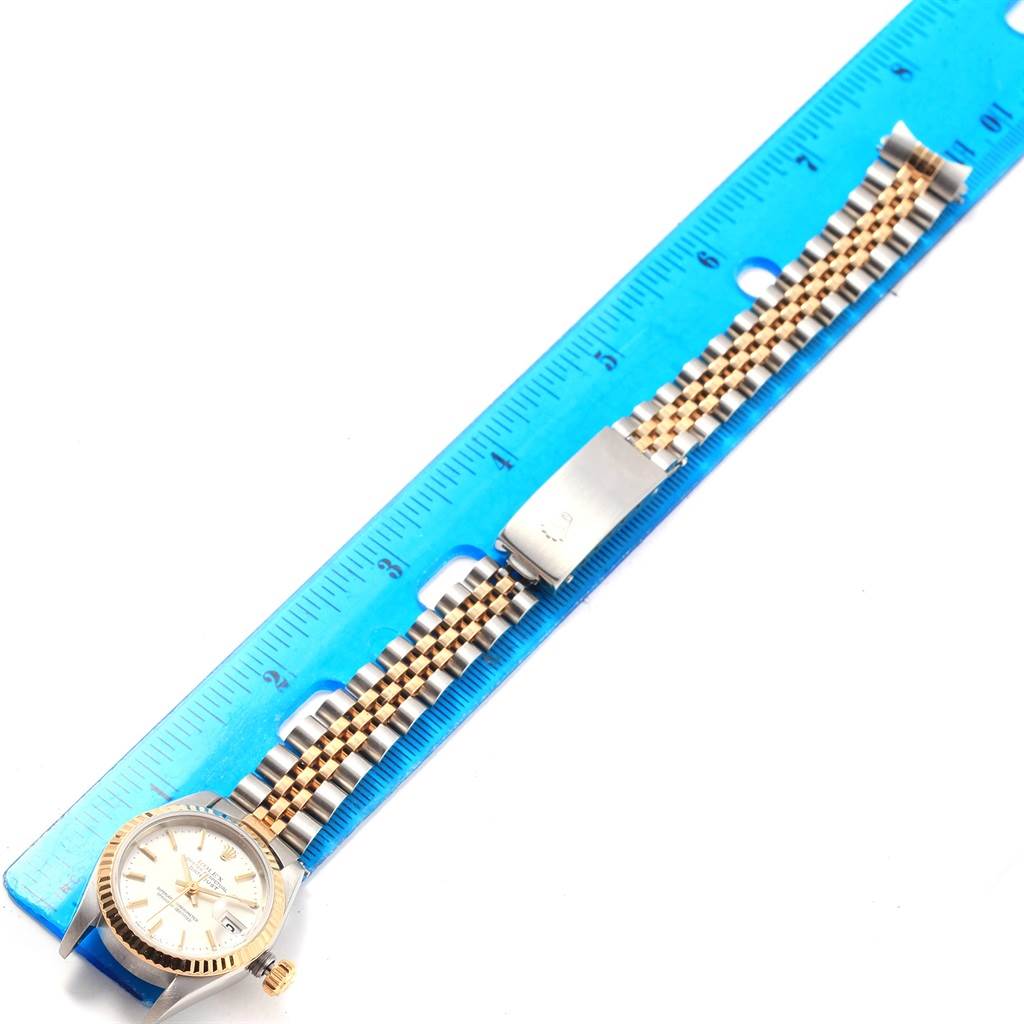 The image shows a Rolex Datejust 79173 Women's Steel and Gold (two tone) Silver Dial 79173 Women's Steel and Gold (two tone) Silver Dial watch laid flat alongside a ruler, highlighting the band length and face with crown.