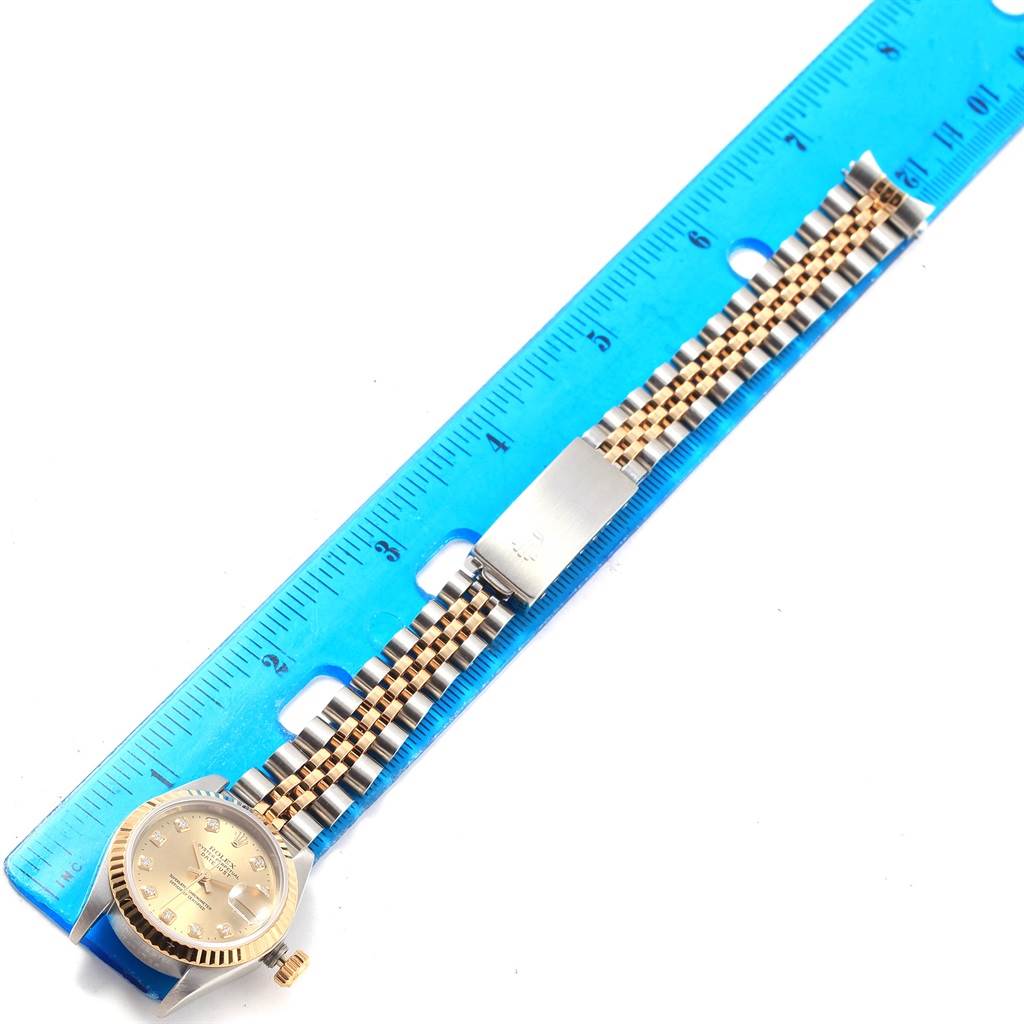 This image shows the Rolex Datejust 69173 Women's Stainless Steel Champagne Dial 69173 Women's Stainless Steel Champagne Dial watch placed next to a ruler, displaying its band and dial from a top-down angle.