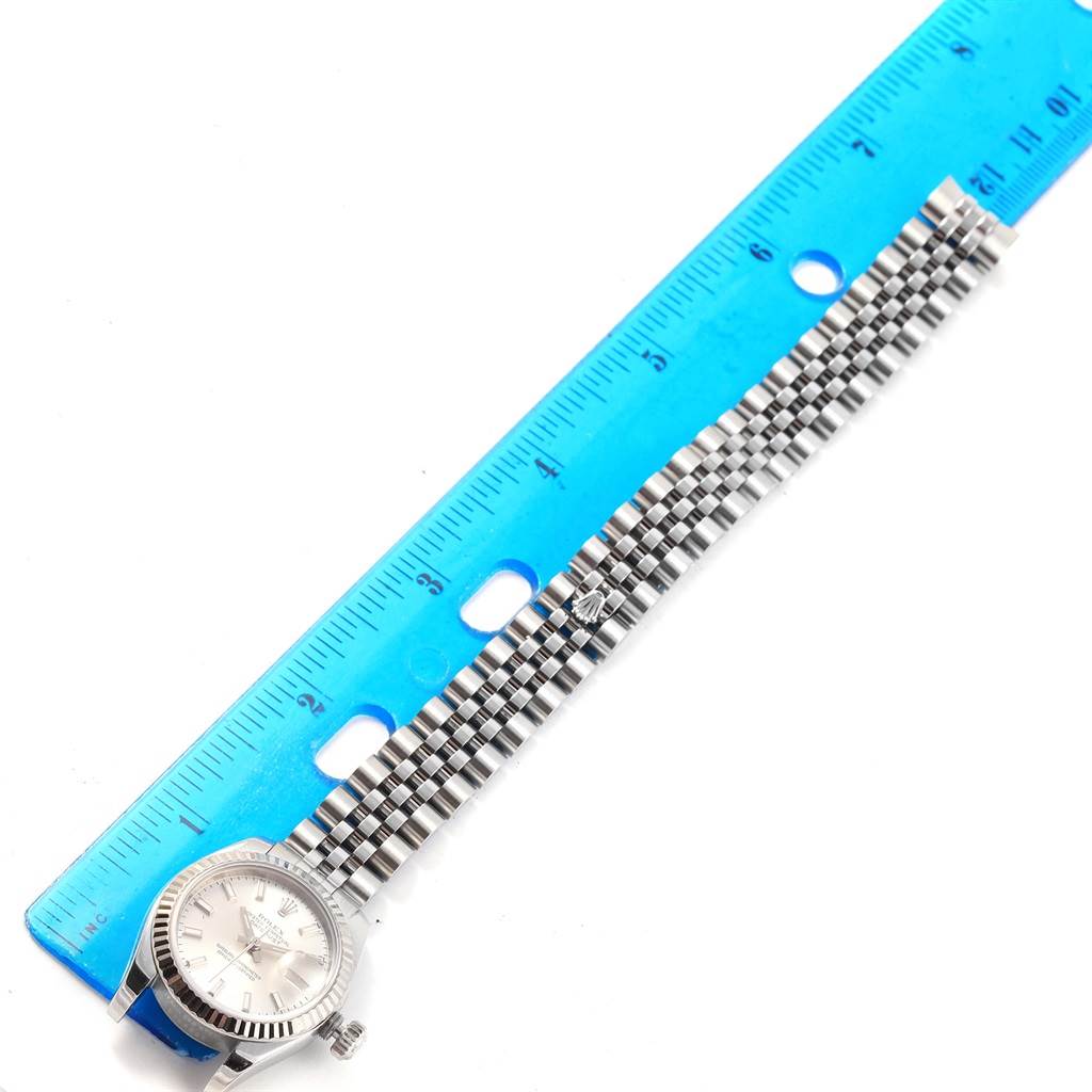 The image shows a top-down view of a Rolex Datejust 179174 Women's Stainless Steel Silver Dial 179174 Women's Stainless Steel Silver Dial watch with its band extended alongside a blue ruler.