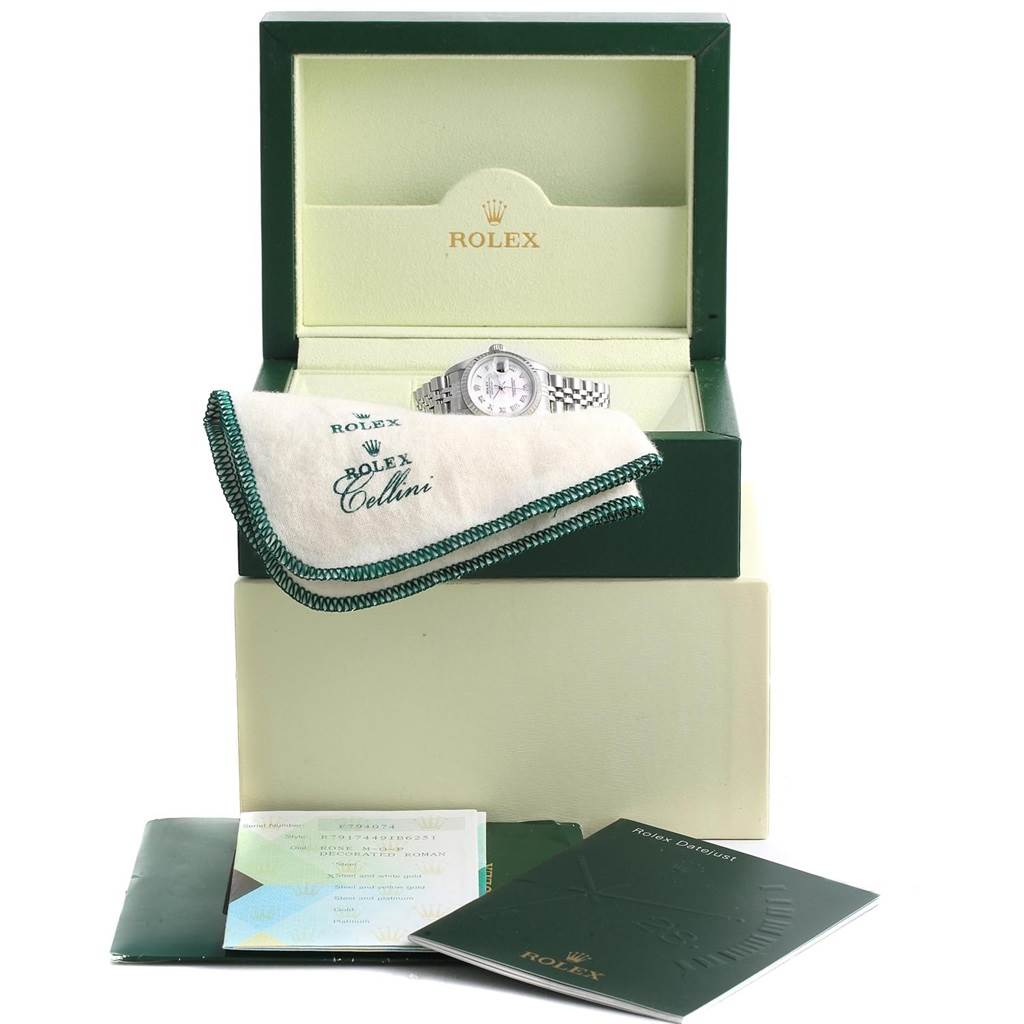 A Rolex Datejust 79174 Women's Stainless Steel Mother of Pearl Dial 79174 Women's Stainless Steel Mother of Pearl Dial watch is displayed in an open watch box, along with its cloth, booklets, and documents.