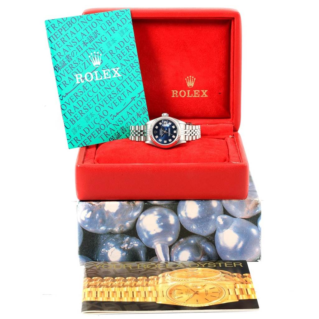 The Rolex Datejust 79174 Women's Stainless Steel Blue Dial 79174 Women's Stainless Steel Blue Dial watch is displayed in its red case, accompanied by booklets, viewed from the front.