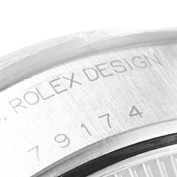 The image shows a close-up of the case back engraving of a Rolex Datejust 79174 Women
s Stainless Steel Silver Dial 79174 Women
s Stainless Steel Silver Dial watch, displaying "ROLEX DESIGN" and serial numbers.