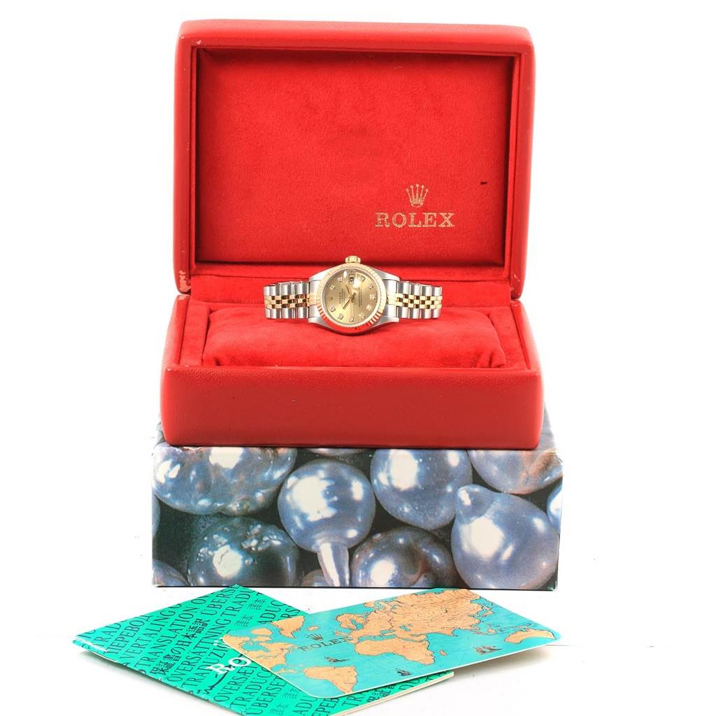 This image shows a Rolex Datejust 69173 Women
s Stainless Steel Champagne Dial 69173 Women
s Stainless Steel Champagne Dial watch in its open red box, along with accompanying paperwork.
