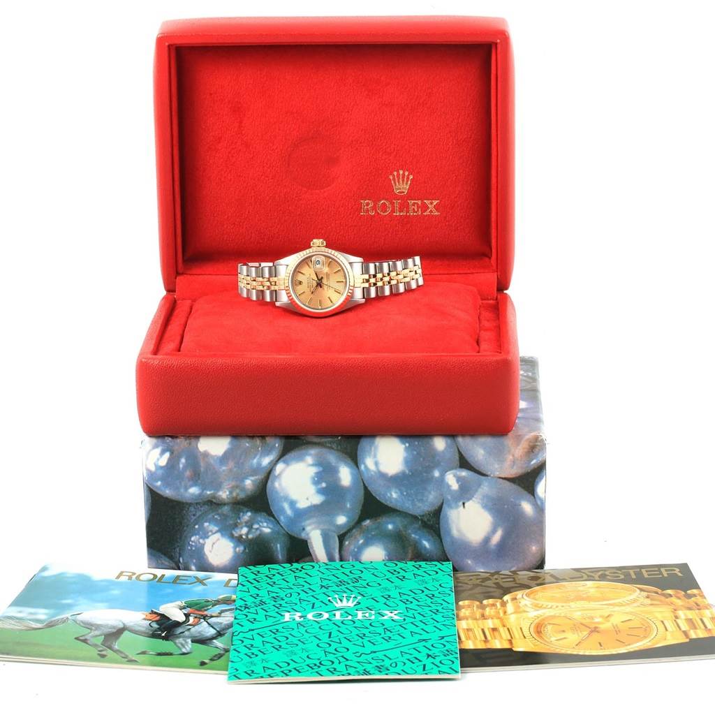 The Rolex Datejust 69173 Women's Stainless Steel Champagne Dial 69173 Women's Stainless Steel Champagne Dial watch is shown from the front, inside a red box with its accessories, including booklets, displayed below.