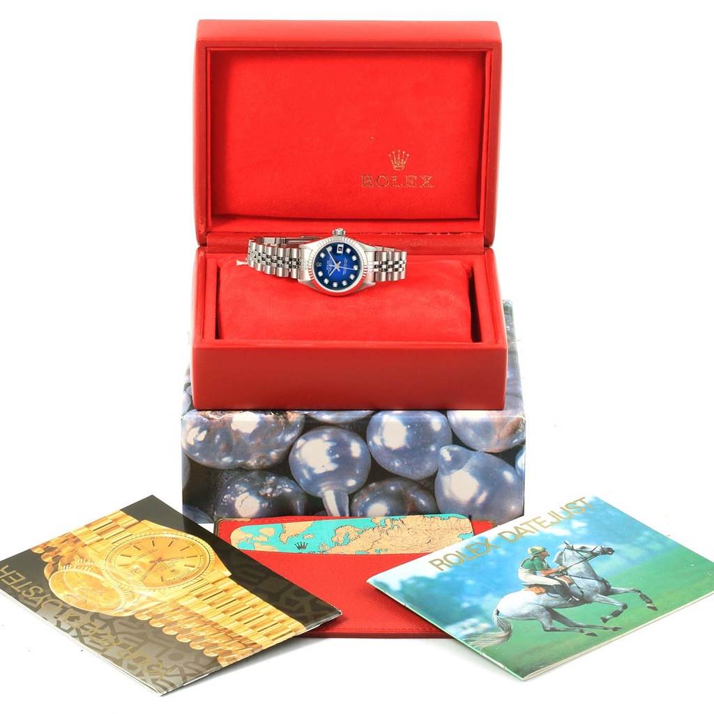 The image shows a Rolex 79174 Men's Stainless Steel Blue Dial 79174 Men's Stainless Steel Blue Dial Datejust model 79174 with a blue diamond dial in its red box, alongside manuals and booklets.