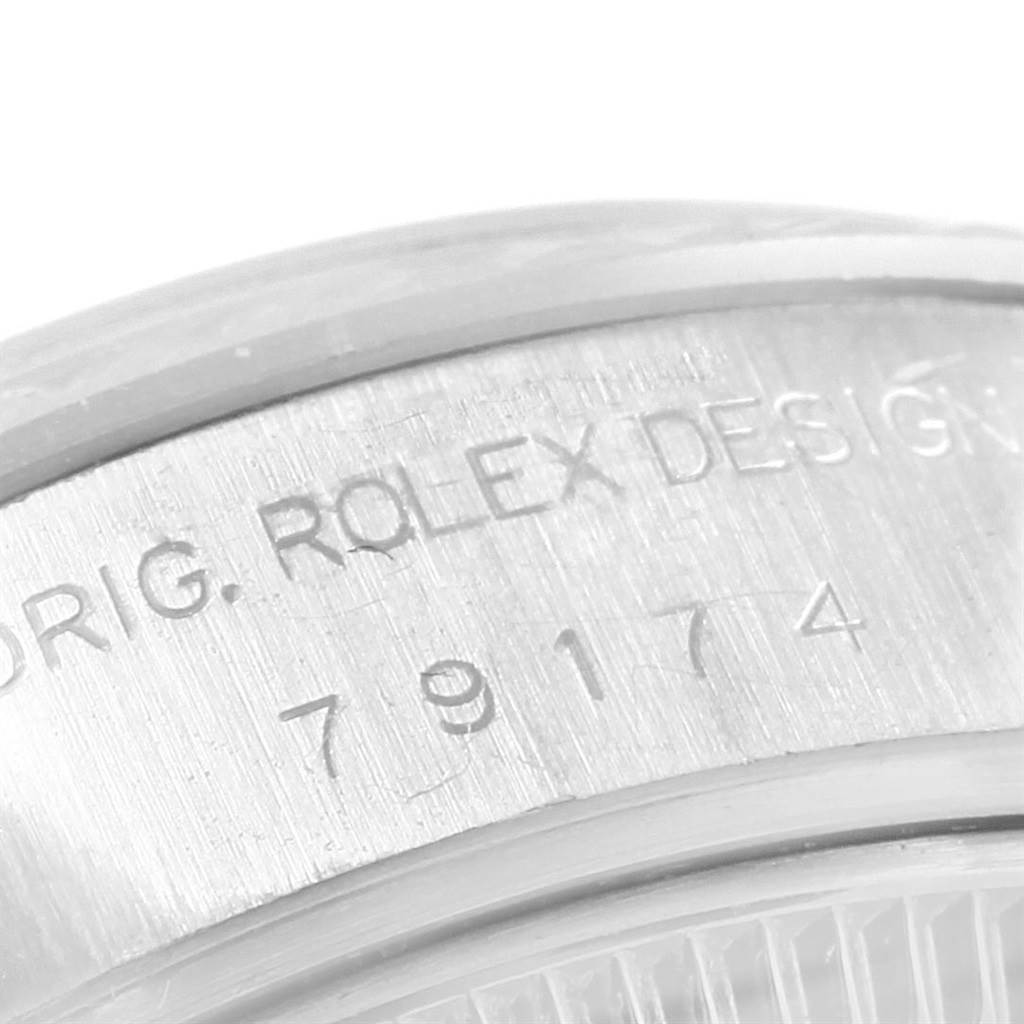 The image shows a close-up of the case side of the Rolex Datejust 79174 Women
s Stainless Steel Blue Dial 79174 Women
s Stainless Steel Blue Dial, displaying the engraved serial and model numbers.