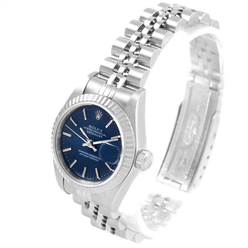 The image shows a Rolex Datejust 79174 Women
s Stainless Steel Blue Dial 79174 Women
s Stainless Steel Blue Dial watch displayed at a three-quarter angle, highlighting its blue dial, fluted bezel, and jubilee bracelet.