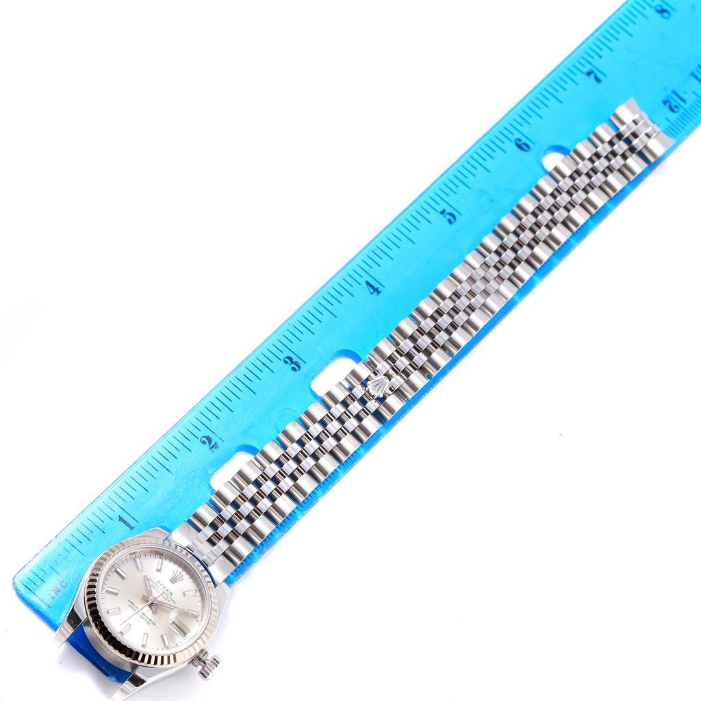 The image shows the Rolex Datejust 179174 Women's Stainless Steel Silver Dial 179174 Women's Stainless Steel Silver Dial watch from a top-down angle, highlighting the dial, bezel, and stainless steel bracelet next to a ruler.