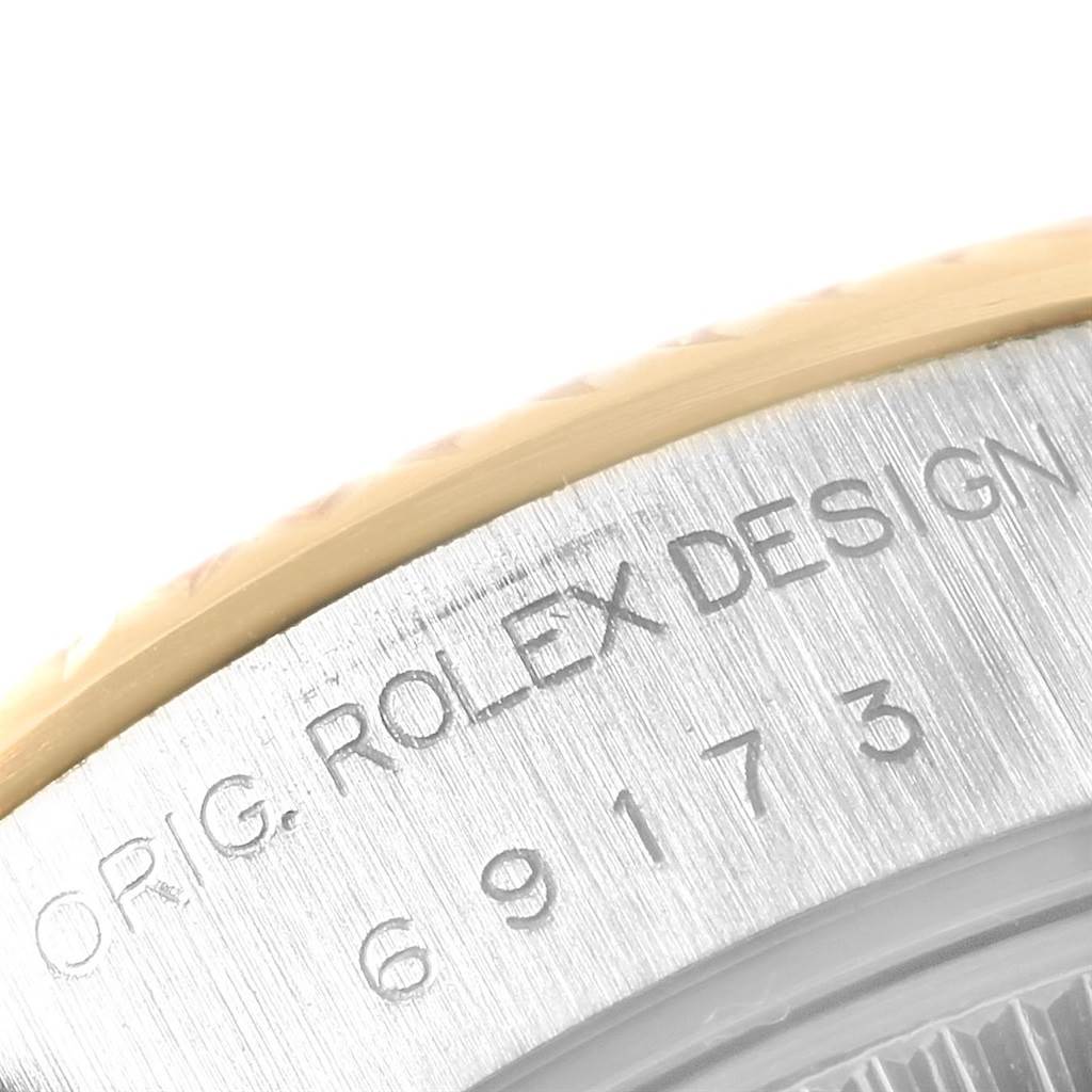 This close-up image shows the engraved model number and "ORIG. ROLEX DESIGN" on the side of the Rolex Datejust 69173 Women
s Stainless Steel White Dial 69173 Women
s Stainless Steel White Dial watch case.