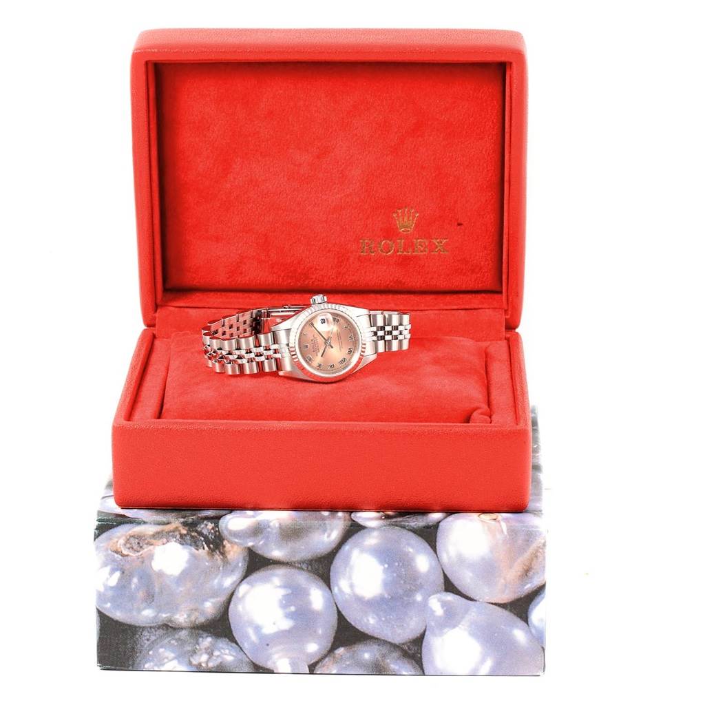 The Rolex Datejust 79174 Women
s Stainless Steel Pink Dial 79174 Women
s Stainless Steel Pink Dial watch is angled front-on, displayed in an open red box with its bracelet extended.