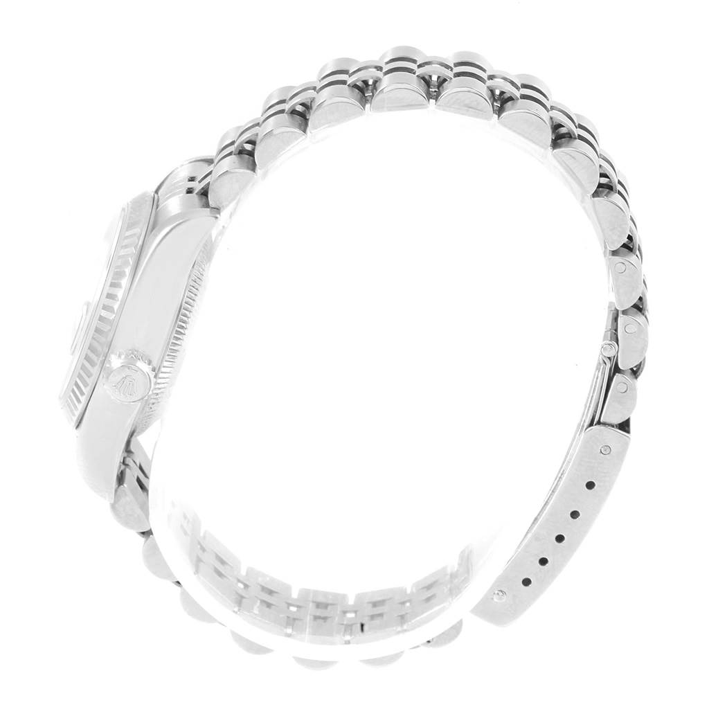 The image shows a Rolex Datejust 79174 Women
s Stainless Steel Pink Dial 79174 Women
s Stainless Steel Pink Dial watch from a side angle, focusing on its case, crown, and bracelet.