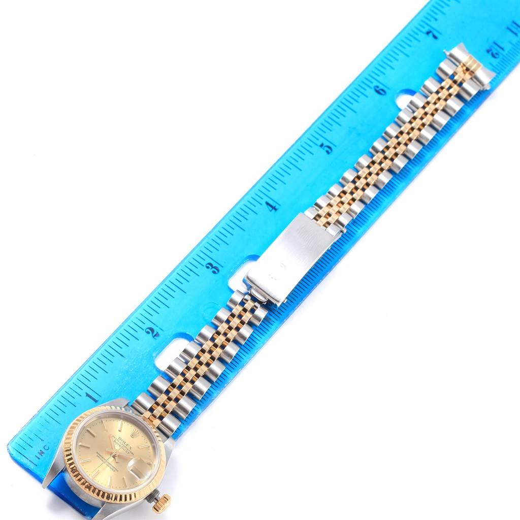 The image shows a Rolex Datejust 79173 Women's Steel and Gold (two tone) Champagne Dial 79173 Women's Steel and Gold (two tone) Champagne Dial watch laid flat with a two-tone bracelet next to a ruler for measurement.