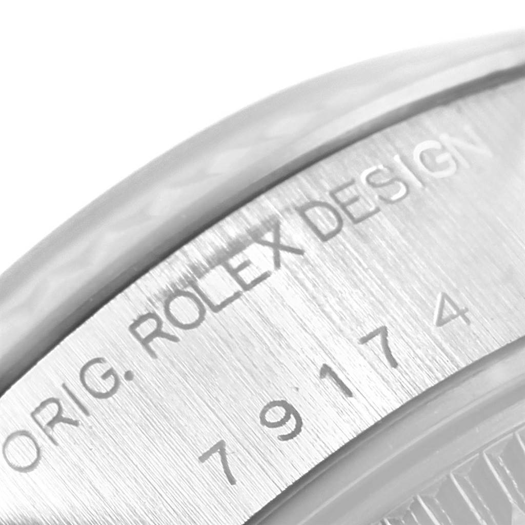 This image shows a close-up of the Rolex Datejust 79174 Women
s Stainless Steel Silver Dial 79174 Women
s Stainless Steel Silver Dial
s side with engraving details and serial numbers.