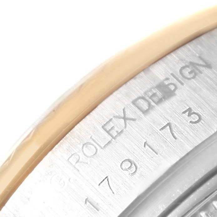 The close-up image shows the edge of the case with engraved text "ROLEX DESIGN" and model number of a Rolex Datejust 179173 Women's Steel and Gold (two tone) Champagne Dial 179173 Women's Steel and Gold (two tone) Champagne Dial watch.