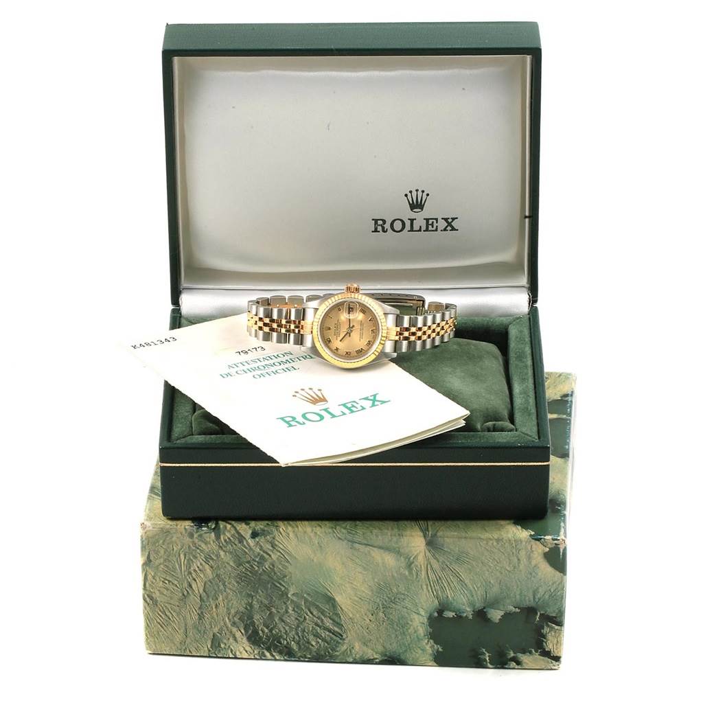 The Rolex Datejust 79173 Women's Steel and Gold (two tone) Champagne Dial 79173 Women's Steel and Gold (two tone) Champagne Dial watch is shown in its open box, viewed from the front and accompanied by official Rolex documents.
